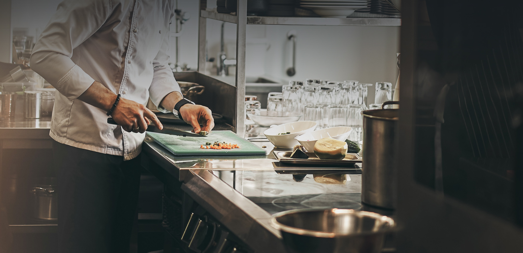 A chef dressed in a white coat working in a kitchen. Credit: Pylup Sukhenko